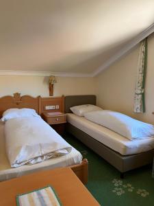 una camera da letto con due letti e un tavolo di Hotel Voglauerhof ad Abtenau