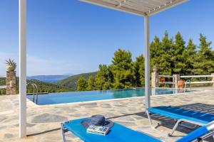 a patio with a blue table and a swimming pool at Villa Salkim in Skopelos Town