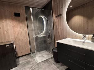 a bathroom with a shower and a sink and a mirror at New modern cabin in Beitostølen in Beitostøl +25 photos