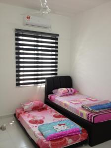 two twin beds in a room with a window at Comfort Holiday Home @ Bukit Indah in Johor Bahru