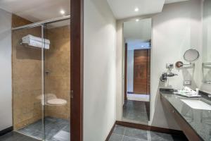 a bathroom with a glass shower and a sink at NH Collection Bogota Hacienda Royal in Bogotá