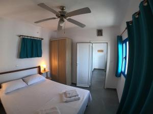 a bedroom with a bed and a ceiling fan at AGIAS PELAGIAS LITTLE BEACH HOUSE in Agia Pelagia Kythira