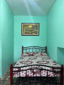 a bed in a room with a blue wall at Zia's homestay-2 in Siquijor +3 photos