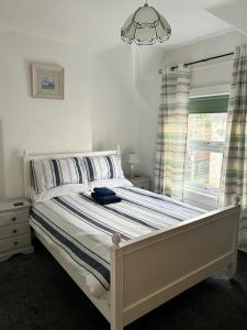 a bedroom with a white bed with a window at Penchwintan in Bangor