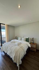Un dormitorio con una cama grande con una ventana grande. en 37 at WildOlive, en Windhoek