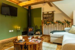 a living room with a couch and a table with a fireplace at Flurry's Lodge in Coleford