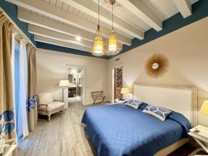 a bedroom with a blue bed and a chair at Hotel San Michele in Trapani +128 photos