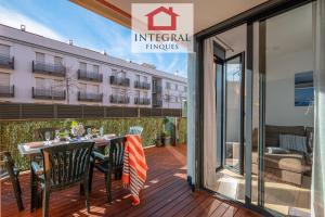 a patio with a table and chairs on a deck at Apartament Cel Blau in Palamós