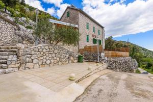 a large stone building with a stone wall at Stone Two Bedroom Villa with Pool in Staševica
