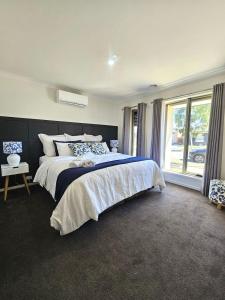a bedroom with a large bed and a window at Cloverton Escape Retreat in Kalkallo