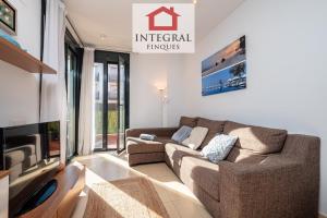 a living room with a couch and a tv at Apartament Cel Blau in Palamós