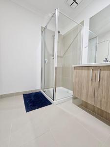a bathroom with a shower and a blue rug at Cloverton Escape Retreat in Kalkallo +47 photos