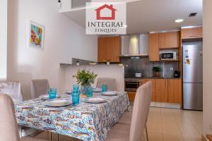 a dining room table with chairs and a kitchen at Apartament Cel Blau in Palamós