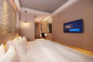 a bedroom with a large bed with a tv on the wall at Guest Hotel in Taipei +62 photos