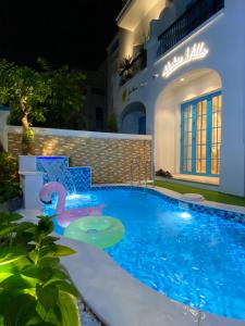 une piscine la nuit avec un cygne au milieu dans l'établissement HT Sea Villa - 7 Bed Rooms, à Hạ Long