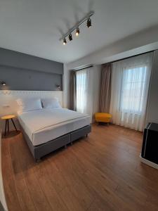 a bedroom with a large bed and a television at QonuQ Bozcaada in Bozcaada