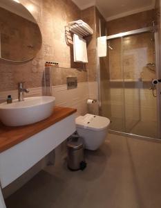 a bathroom with a toilet and a sink and a shower at QonuQ Bozcaada in Bozcaada +32 photos