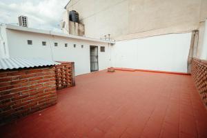 Habitación grande con pared de ladrillo y suelo rojo. en Departamentos Rosina II, en San Fernando del Valle de Catamarca