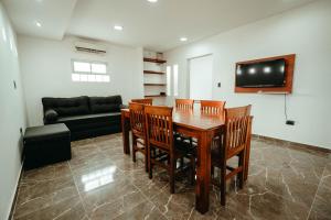 Un comedor con una mesa y sillas y un sofá. en Departamentos Rosina II, en San Fernando del Valle de Catamarca