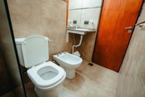 Un baño con inodoro, lavabo y espejo. en Departamentos Rosina II, en San Fernando del Valle de Catamarca