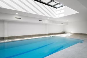 einen großen Pool in einem Zimmer mit einer Decke in der Unterkunft apartamentos con piscina de invierno y garaje ALQUILER TEMPORAL in San Sebastián de los Reyes