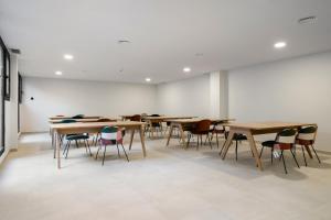 eine Gruppe von Tischen und Stühlen in einem Raum in der Unterkunft apartamentos con piscina de invierno y garaje ALQUILER TEMPORAL in San Sebastián de los Reyes + 149 Fotos