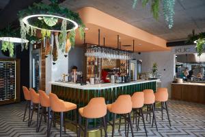 eine Bar mit orangefarbenen Stühlen in einem Restaurant in der Unterkunft Laguna Resort Beskidy & Wellness in Zarzecze + 19 Fotos