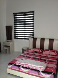 a bedroom with a bed with pink and purple sheets at Comfort Holiday Home @ Bukit Indah in Johor Bahru