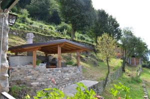 una pared de piedra con un pabellón en una colina en Tra Lago e Montagna Baita la Morena, en Nesso