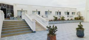 a white building with stairs and potted plants in a courtyard at Nubia Island View Dahab in Dahab