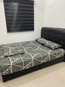 a bed in a bedroom with a black bed frame and a window at homestay d klebang besar in Kelebang Besar