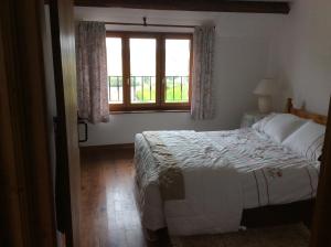 una camera da letto con un letto e una finestra di Grange Cottage a Saint-Dolay