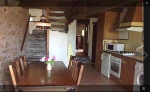 a kitchen with a table and chairs in a room at Grange Cottage in Saint-Dolay
