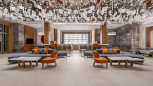 a lobby with blue couches and chairs and a chandelier at Sural Saray Hotel in Side