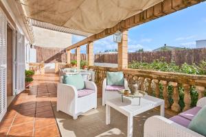 a patio with chairs and tables on a balcony at Villa Martin in Portocolom