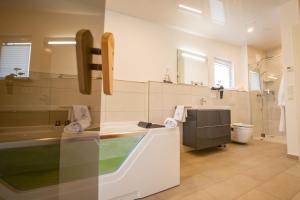 a bathroom with a sink and a tub and a toilet at Baltic Village - VIP Haus in Damp +19 photos