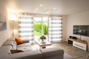 a living room with a couch and a flat screen tv at Baltic Village - VIP Haus in Damp