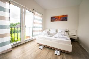 a bedroom with two beds and a large window at Baltic Village - VIP Haus in Damp