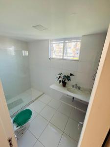 a white bathroom with a toilet and a sink at Hospedaria Catete in Rio de Janeiro