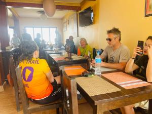 a group of people sitting at tables in a restaurant at Hotel Everest Window View in Nagarkot +23 photos