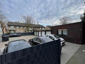 two cars parked in a parking lot in front of a house at MA Apartments - Free Parking, Free WiFi, Relax & Coffee, in Duisburg