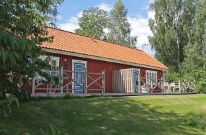 a red house with an orange roof and a yard at Skillingaryds Gård in Skillingaryd
