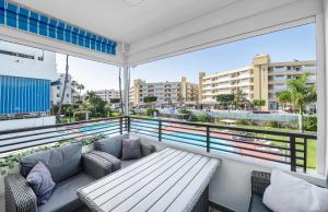 a balcony with a bench and a view of a city at Luxury Pool View Apartment Iguazu in Playa del Ingles
