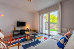 a living room with a couch and a tv at Maison 3 chambres avec jardin, proche métro in Croix