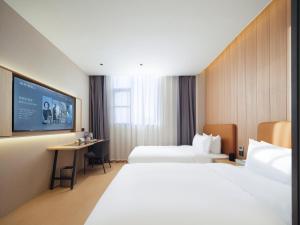 Ein Bett oder Betten in einem Zimmer der Unterkunft 桔作酒店（郑州经开中原福塔东地铁站店）