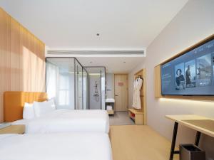 Ein Bett oder Betten in einem Zimmer der Unterkunft 桔作酒店（郑州经开中原福塔东地铁站店）