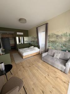 a living room with a bed and a couch at Angyal Villa in Rátka