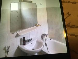 ein Badezimmer mit Waschbecken, Badewanne und Spiegel in der Unterkunft Marrakech village touristique in Marrakesch