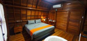 una camera da letto con un letto in una stanza con pareti in legno di Palma Beach Resort a Krui