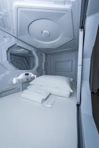 Postel nebo postele na pokoji v ubytování Kiwi Capsule Hotel